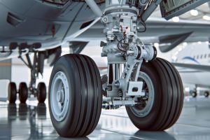 Aviation landing gear with hydraulic systems and wheels at an aircraft maintenance hangar.